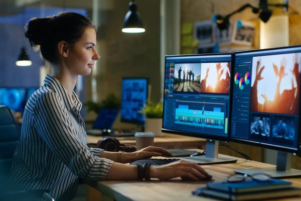 Beautiful Female Video Editor Works with Footage on Her Personal Computer, She Works in Creative Office Studio. Beautiful Female Video Editor Works with Footage on Her Personal Computer, She Works in Creative Office Studio.